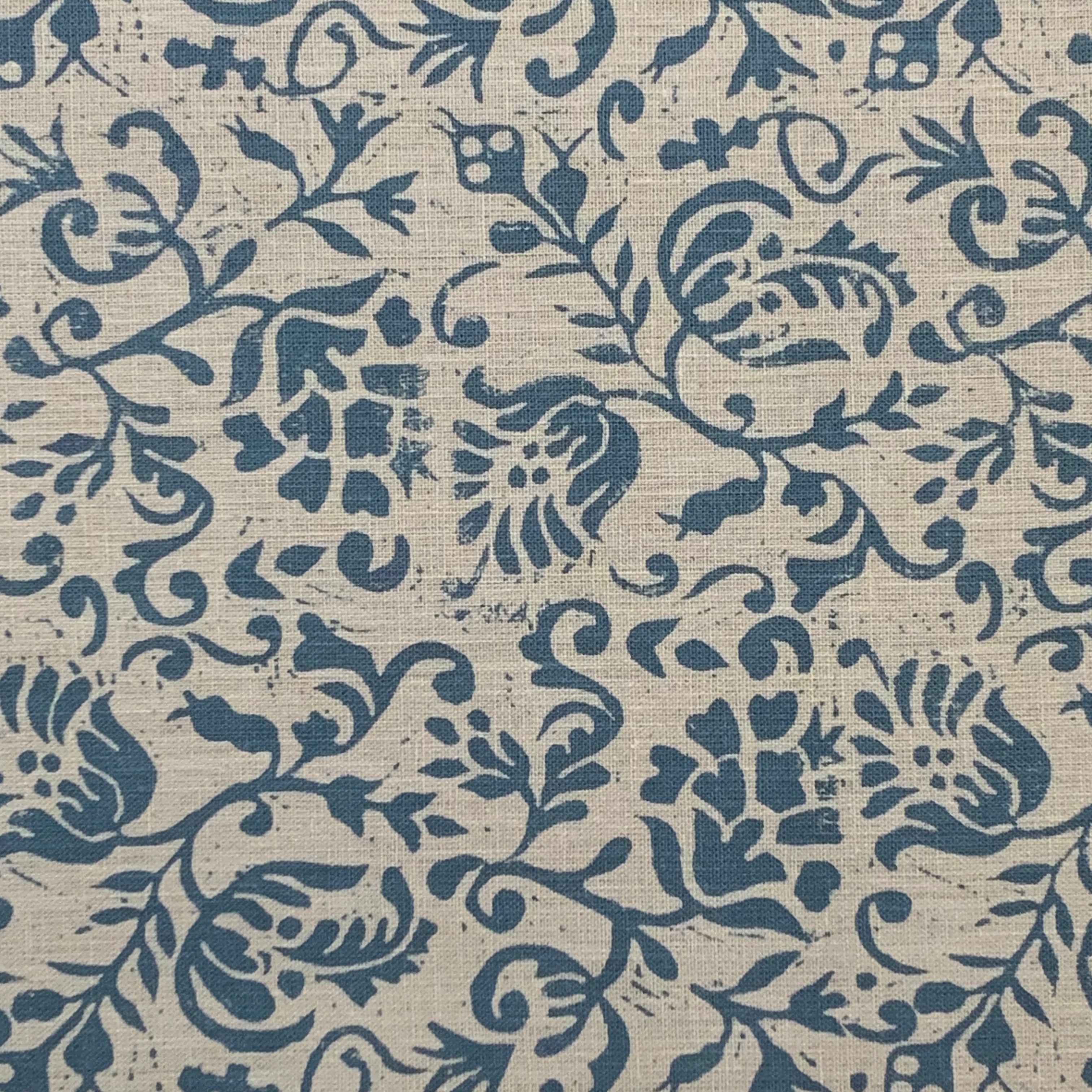 Textile pattern with blue floral and leaf designs on a beige background