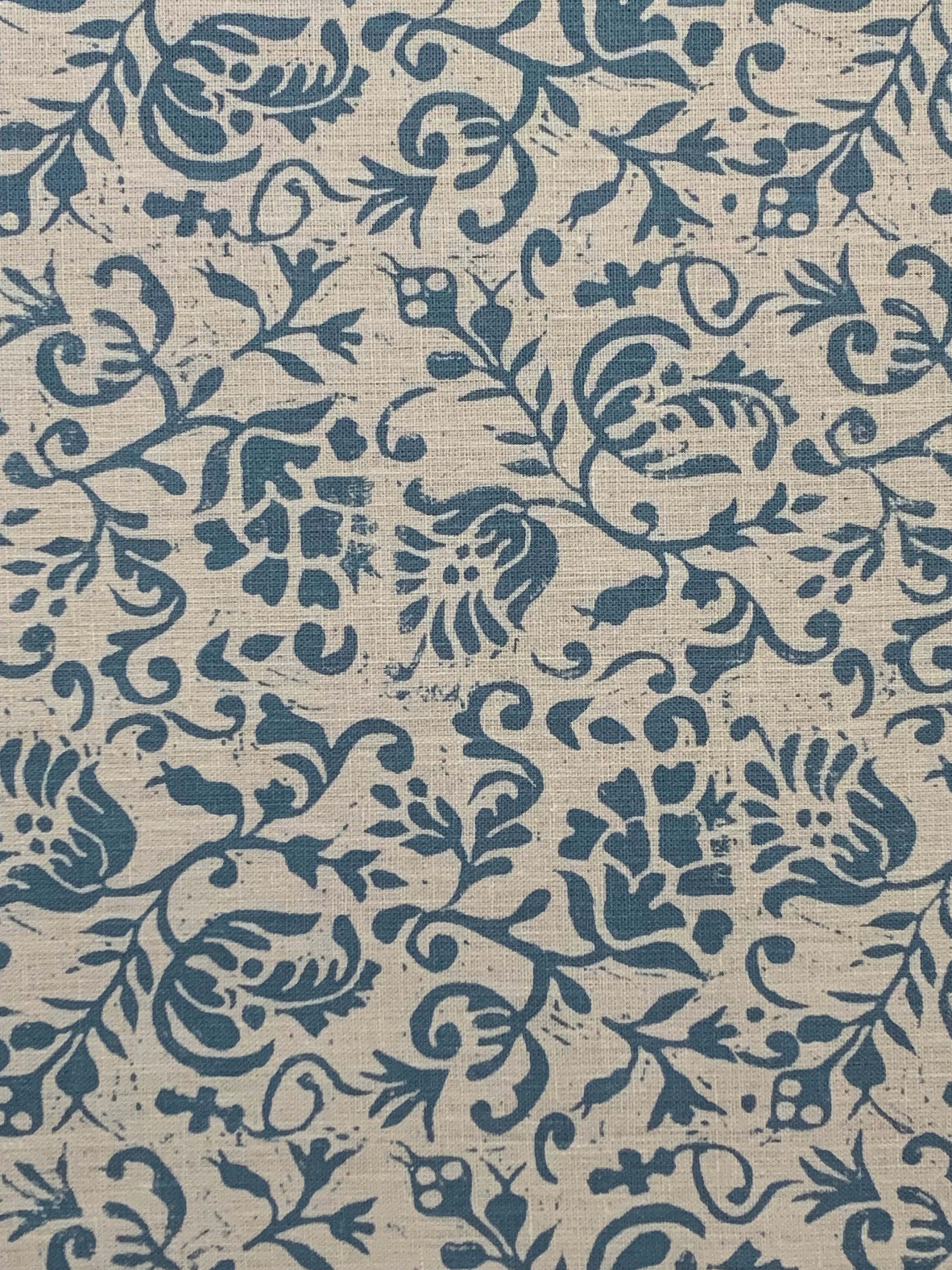 Textile pattern with blue floral and leaf designs on a beige background