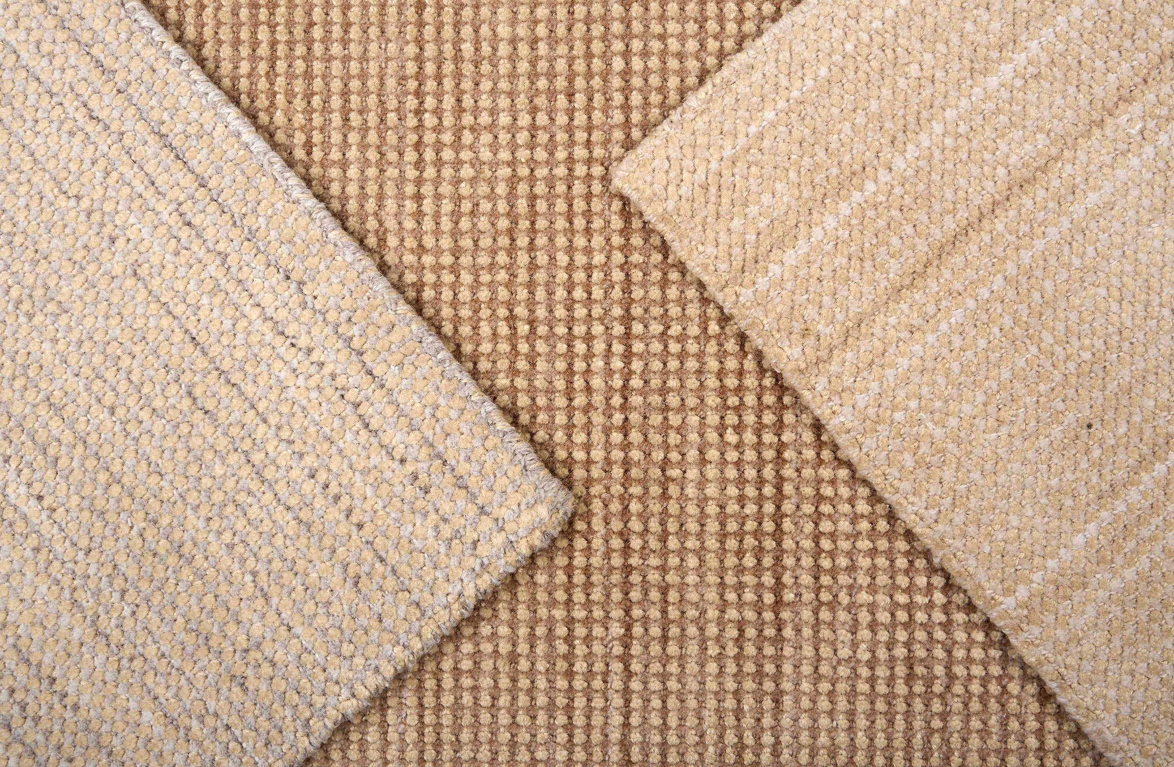 Close up of broadloom carpet samples in neutral colors. 