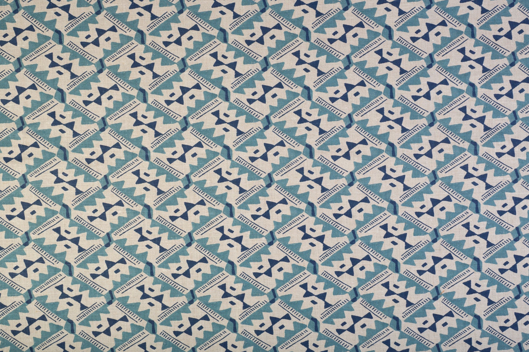 Detail of fabric in painterly diamond print in blue and navy on a white field.