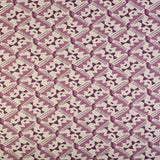 Detail of fabric in painterly diamond print in shades of purple on a white field.