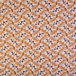 Detail of fabric in painterly diamond print in maroon and orange on a white field.