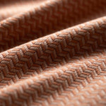 Close-up of textured brown fabric with a herringbone pattern