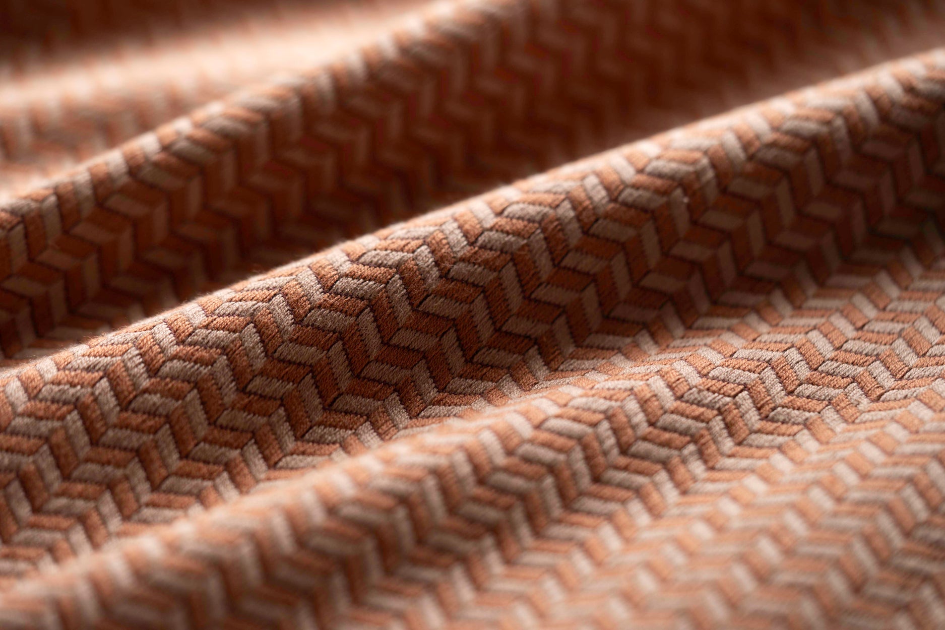 Close-up of textured brown fabric with a herringbone pattern
