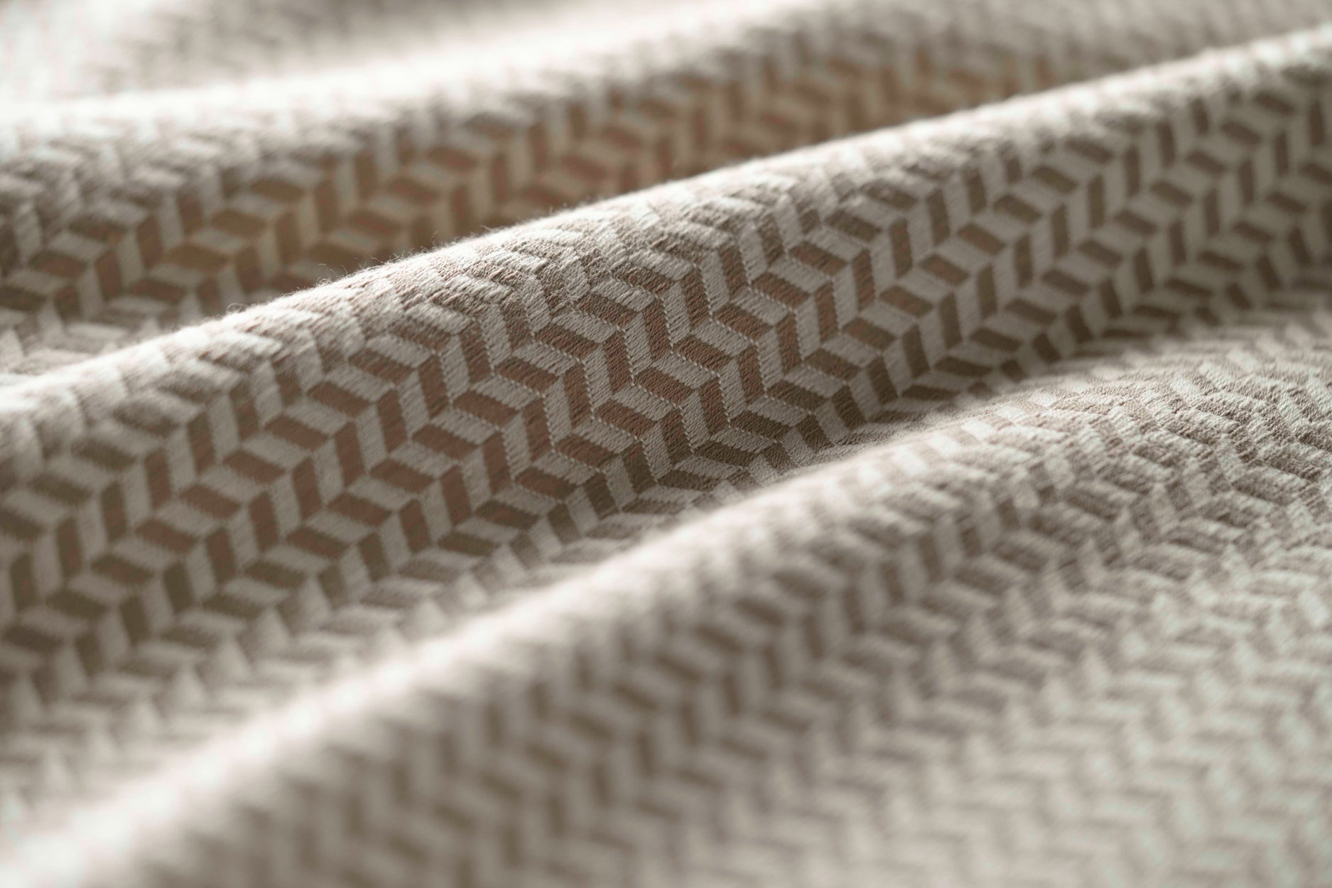 Close-up of a textured fabric with a geometric pattern in beige. 