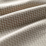 Close-up of a textured fabric with a geometric pattern in beige. 