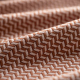 Close-up of brown textured fabric with a herringbone pattern light folded. 