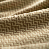 Close-up of a taupe textured fabric with a herringbone pattern light folded. 