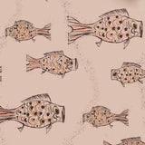 Close up of wallpaper with a pattern of hand-drawn fish in black with tan and pink scales and scattered black bubble dots on light pink. 
