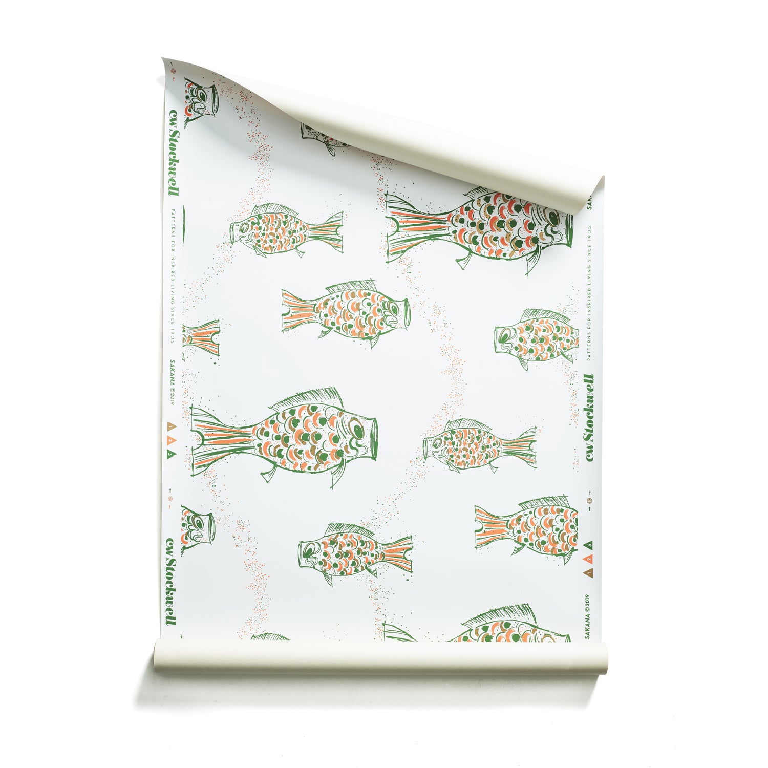 Roll of wallpaper with a pattern of hand-drawn fish in green with brown and orange scales and scattered bubble dots on white.