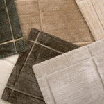 Pile of broadloom carpet samples in rich neutrals 