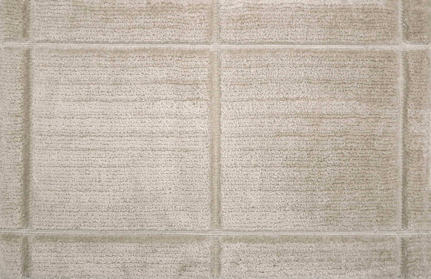 Textural performance broadloom carpet in grid design in beige.