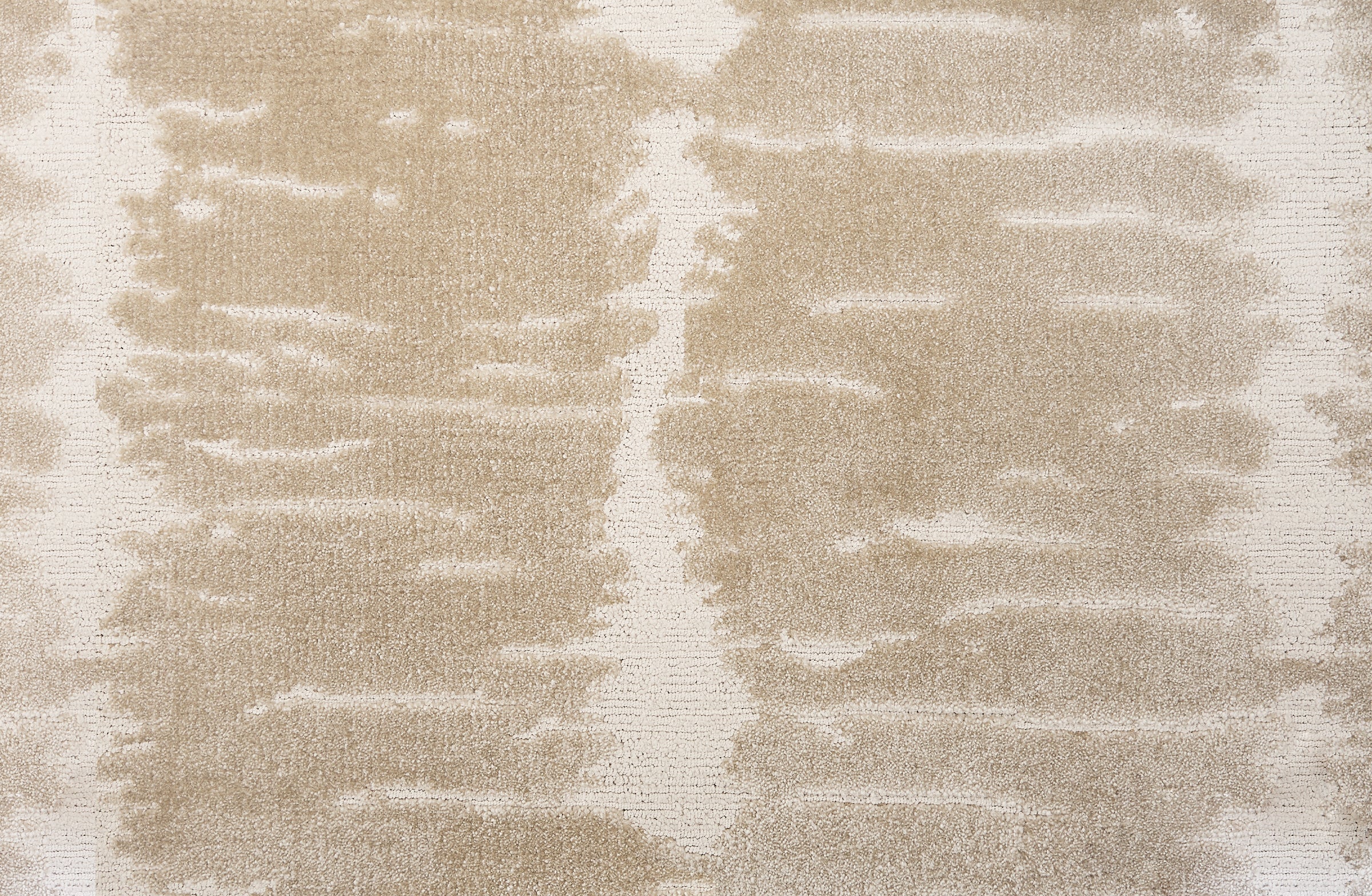 Broadloom carpet in a dimensional abstract painterly pattern in warm beige on a cream field.
