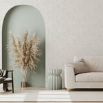 A modernist living room with a wall papered in a painterly abstract print in white on a light gray field.