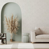 A modernist living room with a wall papered in a painterly abstract print in white on a light gray field.