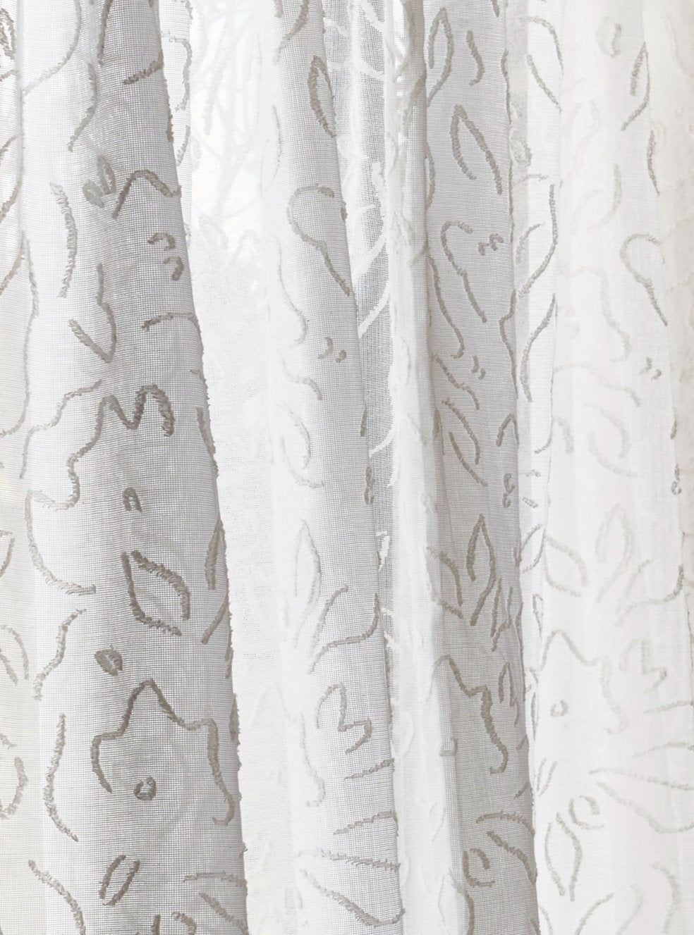 Draped sheer fabric in a hand drawn floral pattern in ivory.