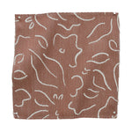 Textile sample with white floral pattern on brown background