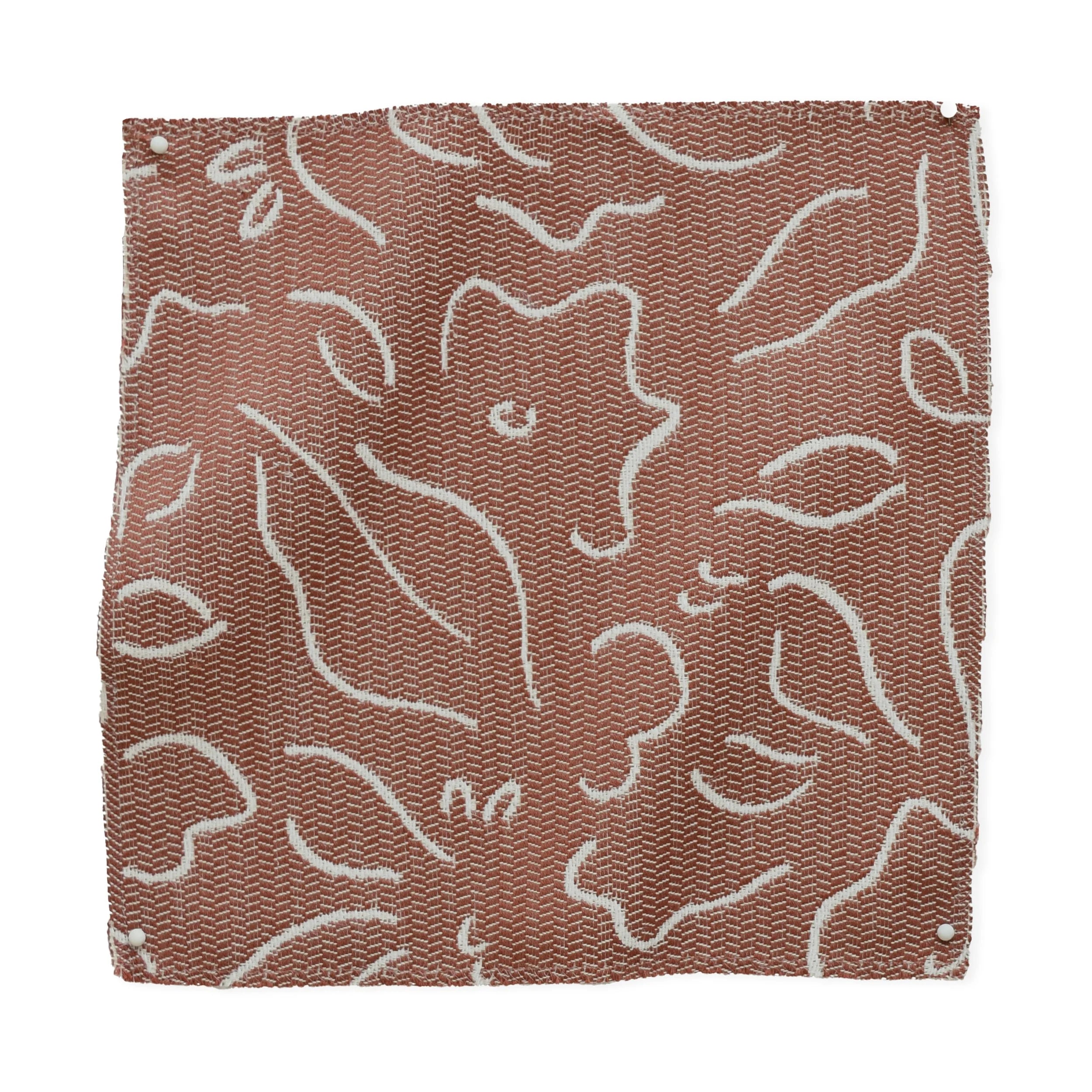 Textile sample with white floral pattern on brown background