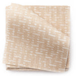 A stack of fabric swatches in a small-scale grid pattern in shades of cream and tan.