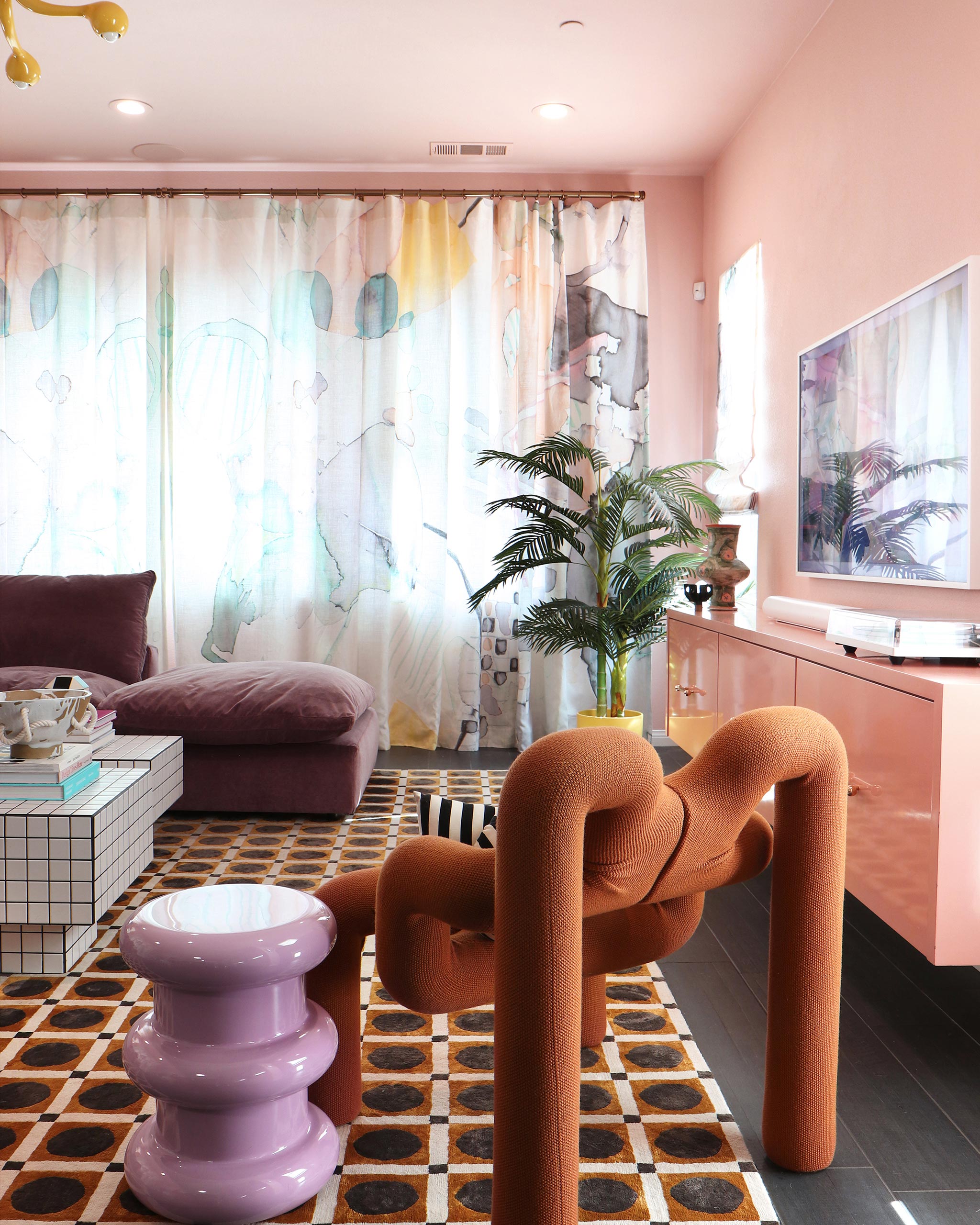 A funky modernist living room with floor-length curtains in a watercolor watercolor print in pastels on a white field.