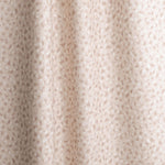 Gently draped fabric in a painterly animal print in pastel pink with white accents. 