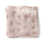 Stacked swatches of fabric in a painterly animal print in pastel pink with white accents. 
