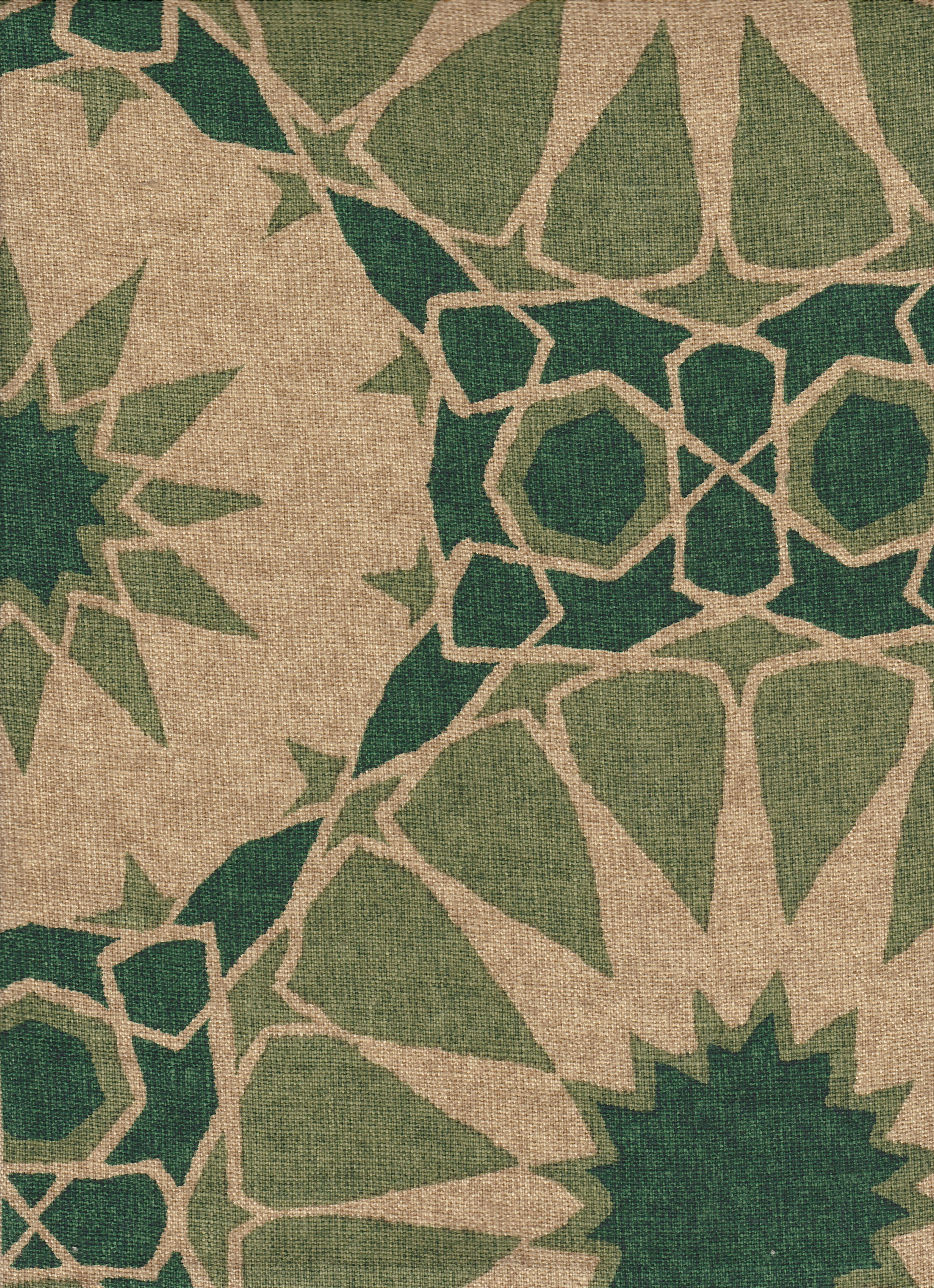 Detail of fabric in a geometric Moroccan print in shades of green and tan.