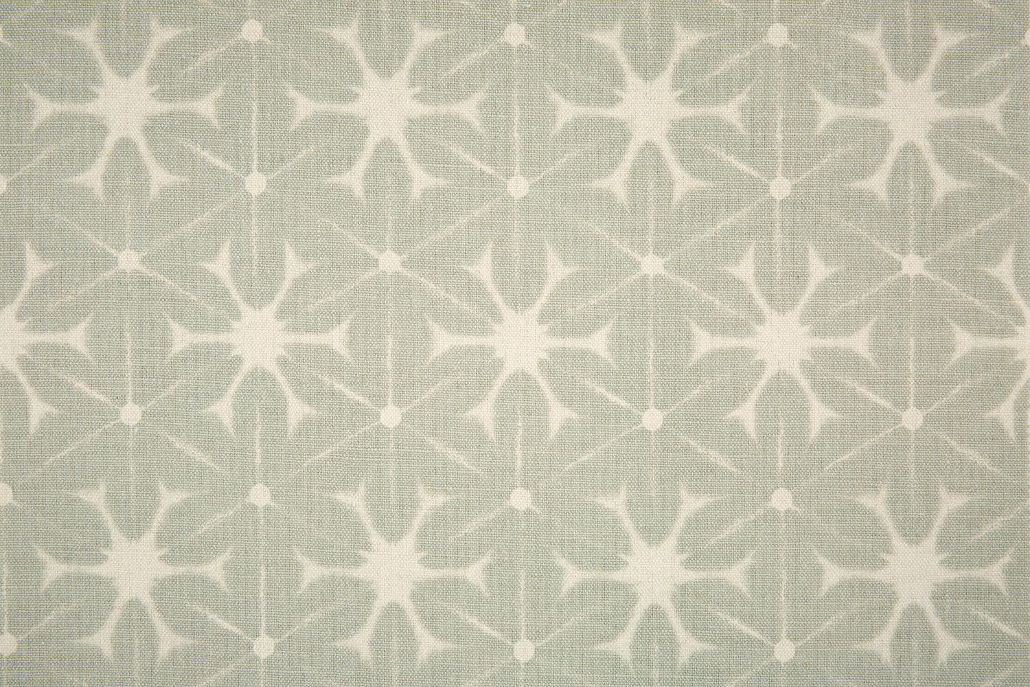 Detail of fabric in a shibori grid print in white on a gray field.