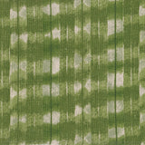 Detail of fabric in a textural shibori print in shades of green on a greige field.