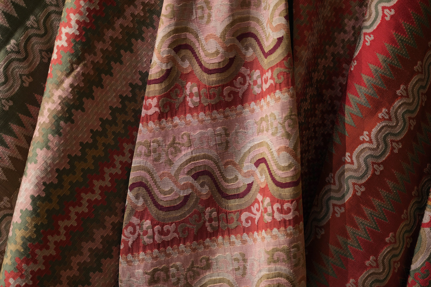 Close-up of patterned fabric with red, green, and beige colors.