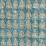 Detail of fabric woven in a repeating leaf print in shades of blue and gold.
