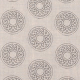 Detail of fabric in a repeating circular geometric print in gray on a cream field.
