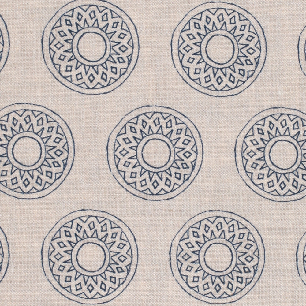 Detail of fabric in a repeating circular geometric print in navy on a cream field.