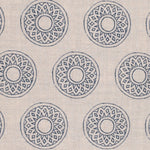 Detail of fabric in a repeating circular geometric print in navy on a cream field.