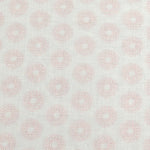 Detail of fabric in a repeating circular geometric print in light pink on a greige field.