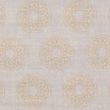 Detail of fabric in a repeating circular geometric print in yellow on a greige field.
