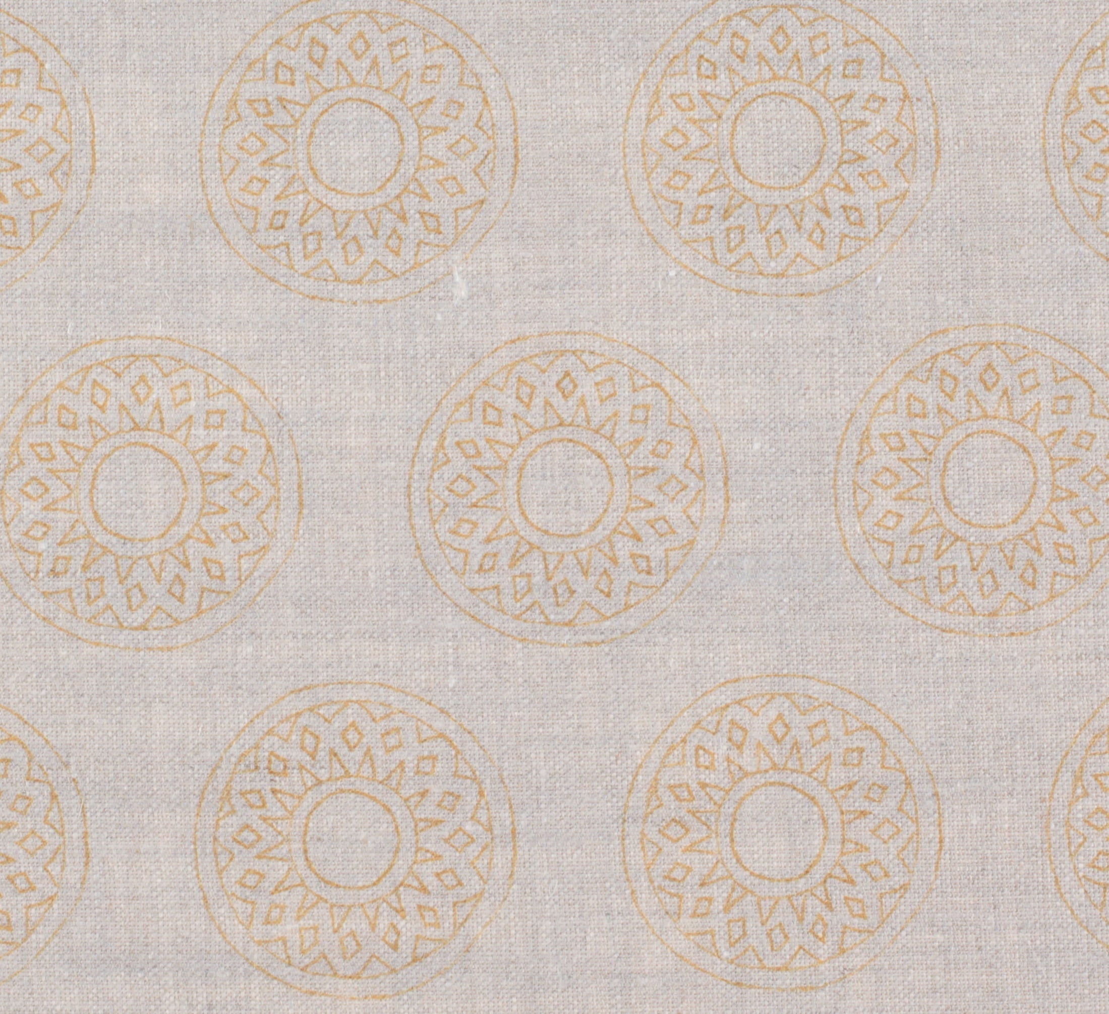 Detail of fabric in a repeating circular geometric print in yellow on a greige field.