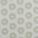 Detail of fabric in a repeating circular geometric print in green on a greige field.