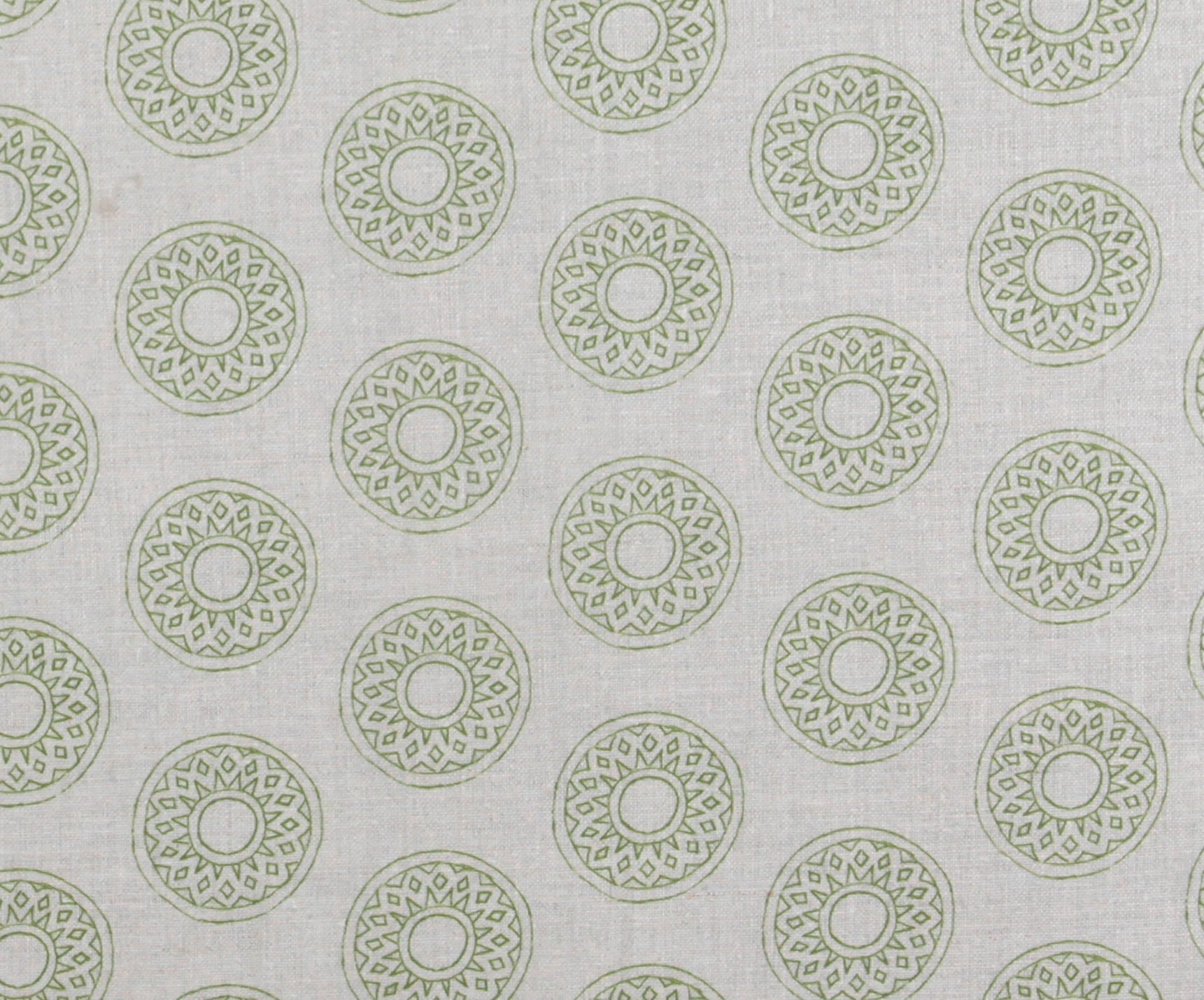Detail of fabric in a repeating circular geometric print in green on a greige field.