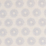 Detail of fabric in a repeating circular geometric print in light blue on a cream field.