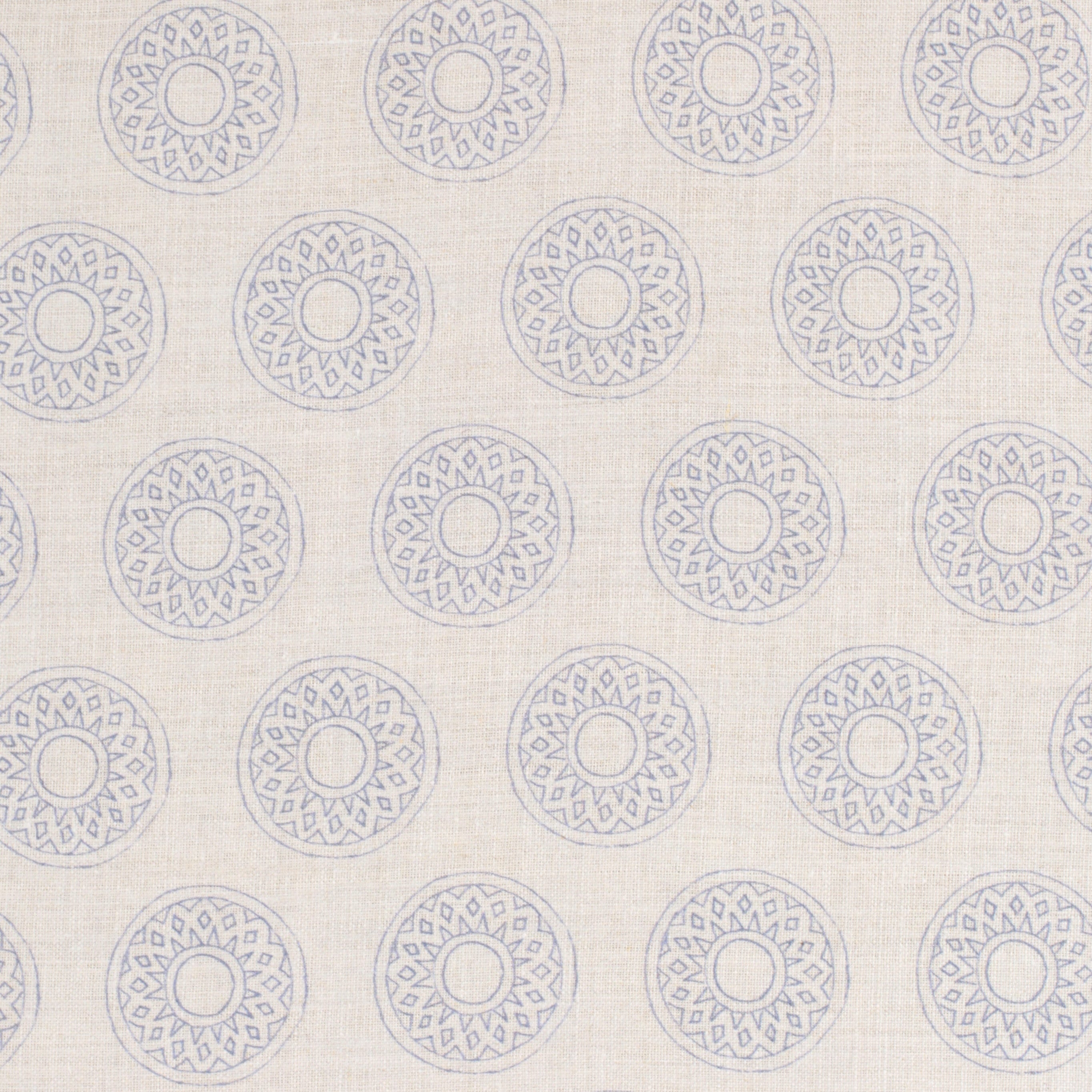 Detail of fabric in a repeating circular geometric print in light blue on a cream field.