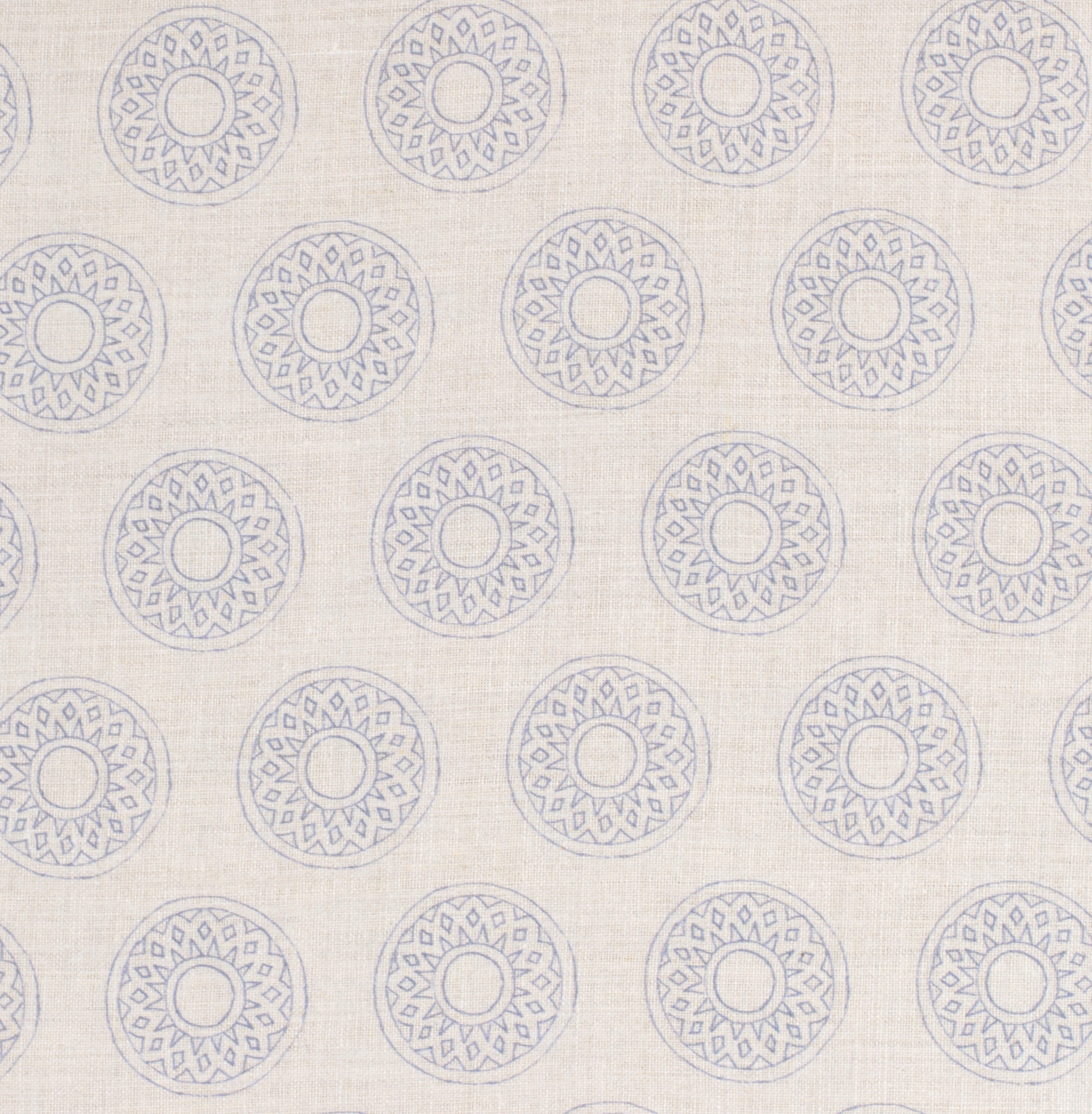 Detail of fabric in a repeating circular geometric print in light blue on a cream field.