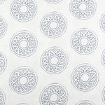 Detail of fabric in a repeating circular geometric print in gray on a white field.