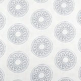 Detail of fabric in a repeating circular geometric print in gray on a white field.