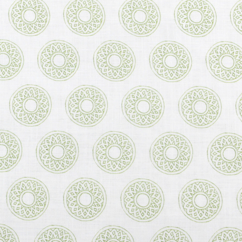 Detail of fabric in a repeating circular geometric print in green on a white field.