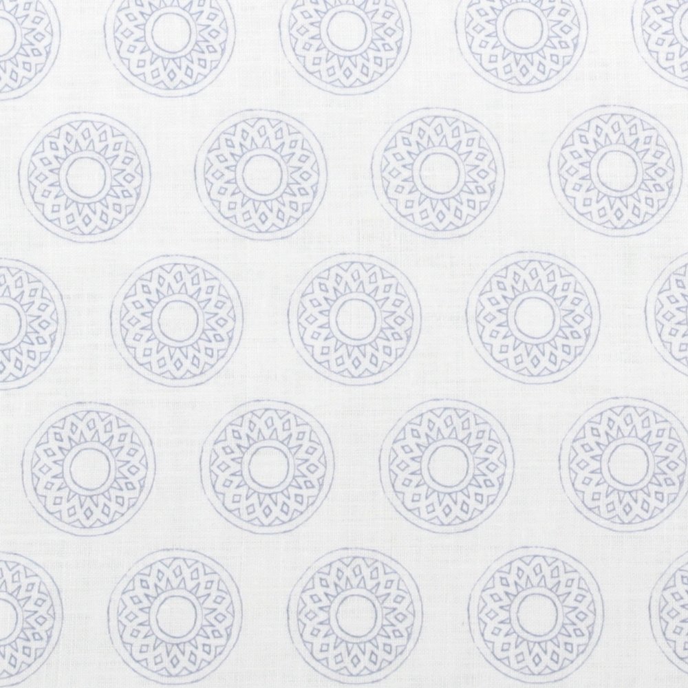 Detail of fabric in a repeating circular geometric print in light blue on a white field.