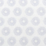 Detail of fabric in a repeating circular geometric print in light blue on a white field.