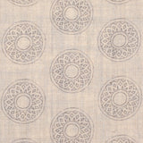 Detail of fabric in a repeating circular geometric print in light gray on a tan field.