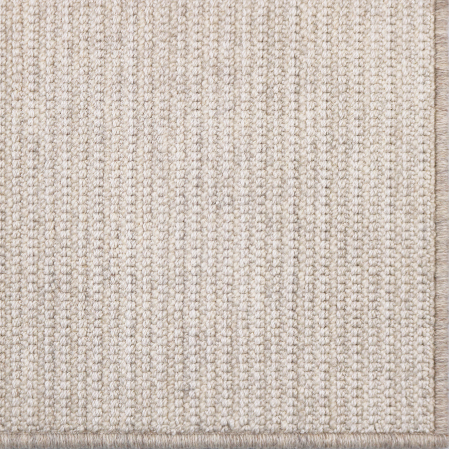 Close-up of a textured beige rug with a subtle pattern
