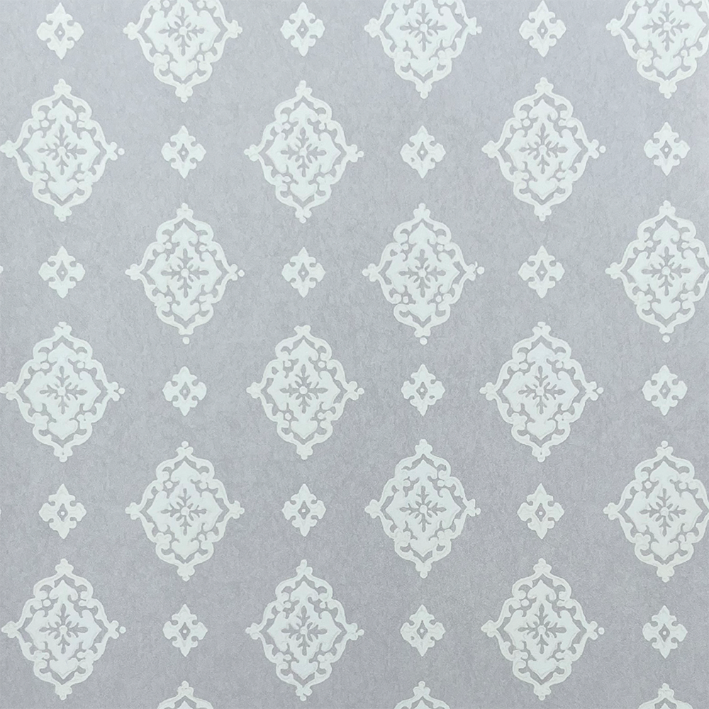 Detail of fabric in a floral damask print in white on a light gray field.
